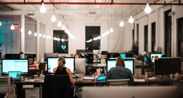 Computer room with individuals seated at desks working